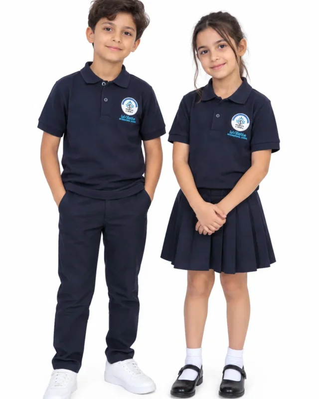 Écolier et écolière en polo bleu marine brodé au logo de l’école, pantalon et jupe plissée bleu marine