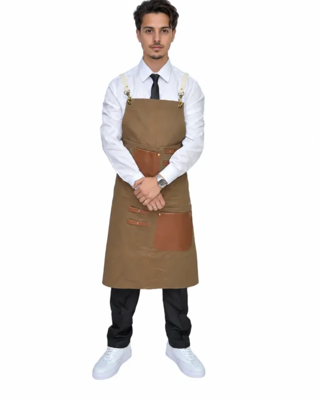 Barista en tablier marron à bretelles en cuir sur chemise blanche