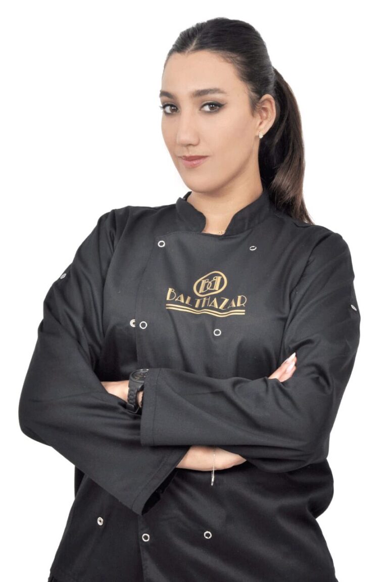 Cuisinière en veste de cuisine noire brodée au logo du restaurant